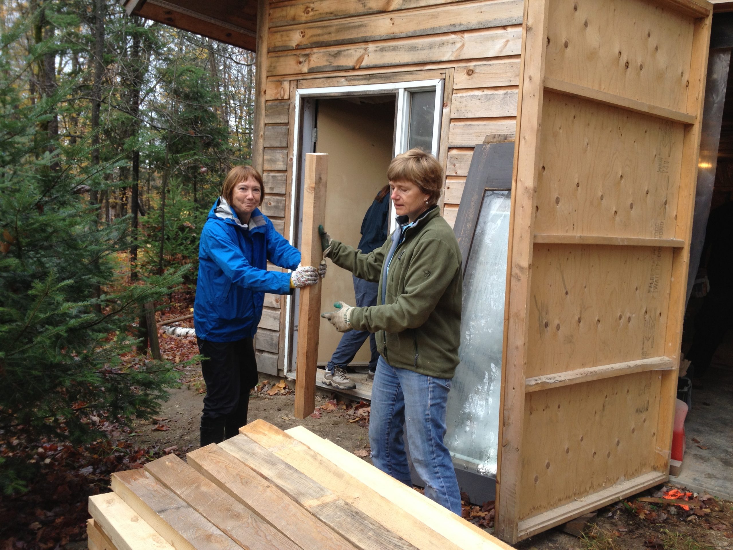 Two people working on building a shed